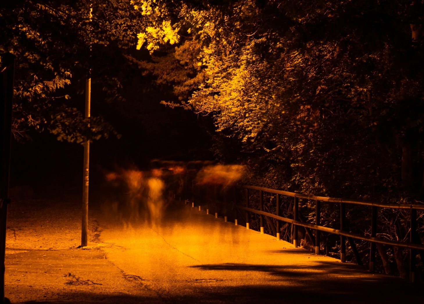 An image a night with translucent ghosts floating under the streetlight