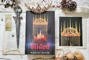 In an article about Gilded by Marissa Meyer, an image of the book on an aesthetic background.