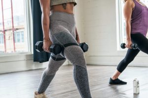 in article about anxiety at the gym, a photo of two people lifting weights