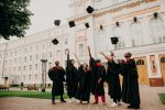 a group of college graduates after graduation throwing their mortarboards in the air