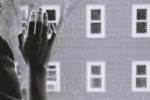 in an article about depression, someone whose hand is on a window