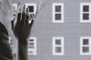 in an article about depression, someone whose hand is on a window