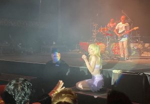Carly Rae Jepsen crouching on a platform during a performance