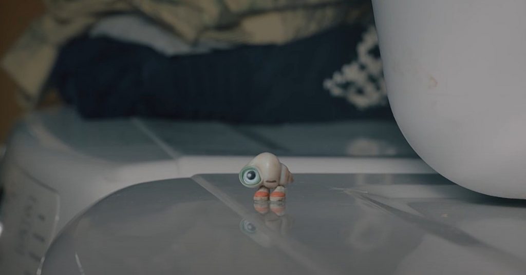 Marcel the Shell stares off into the distance on top of a washing machine