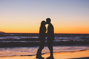 in an article about dating sites, a silhouette of a couple kissing on the beach