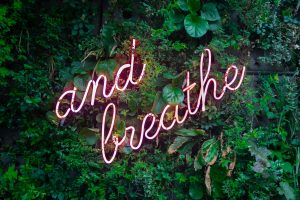 in article about self-care, a sign that reads 'and breathe'