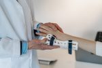 An image of concierge medicine shows a doctor putting a brace on a patient's hand