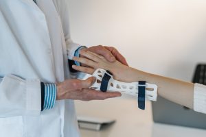 An image of concierge medicine shows a doctor putting a brace on a patient's hand