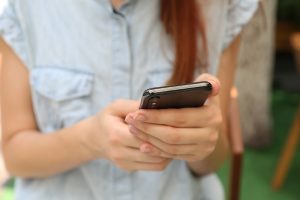 in an article about Canadian apps, someone holding a phone looking at apps