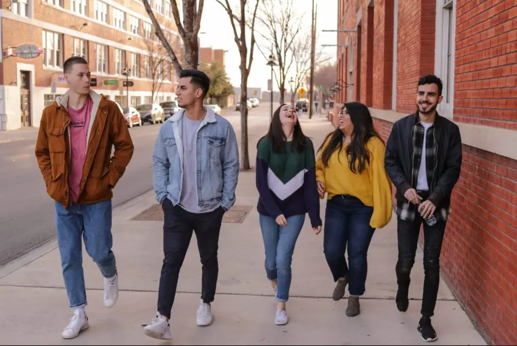 a photo of five students walking on a college campus