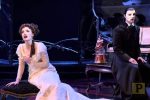 A screenshot from love never dies shows a female singing next to the phantom of the opera
