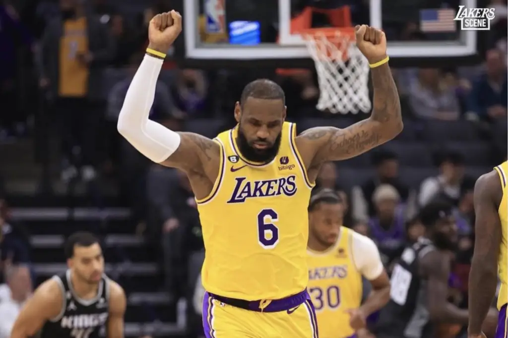 in article about lebron james and meme culture, image on james with arms over head playing basketball in lakers jersey