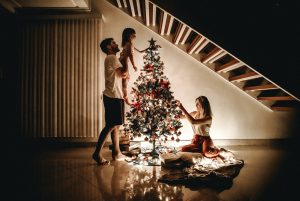 in article about the holidays, image of a family decorating a christmas tree