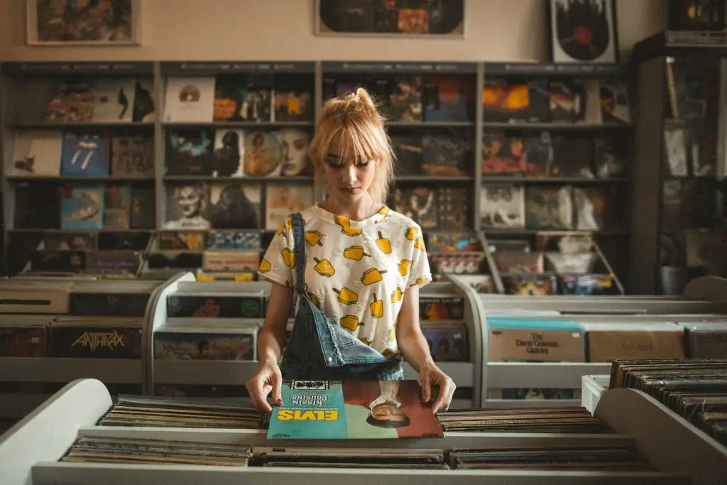 In an article about what to get your musician friend, a woman looks at an Elvis record in a record shop.