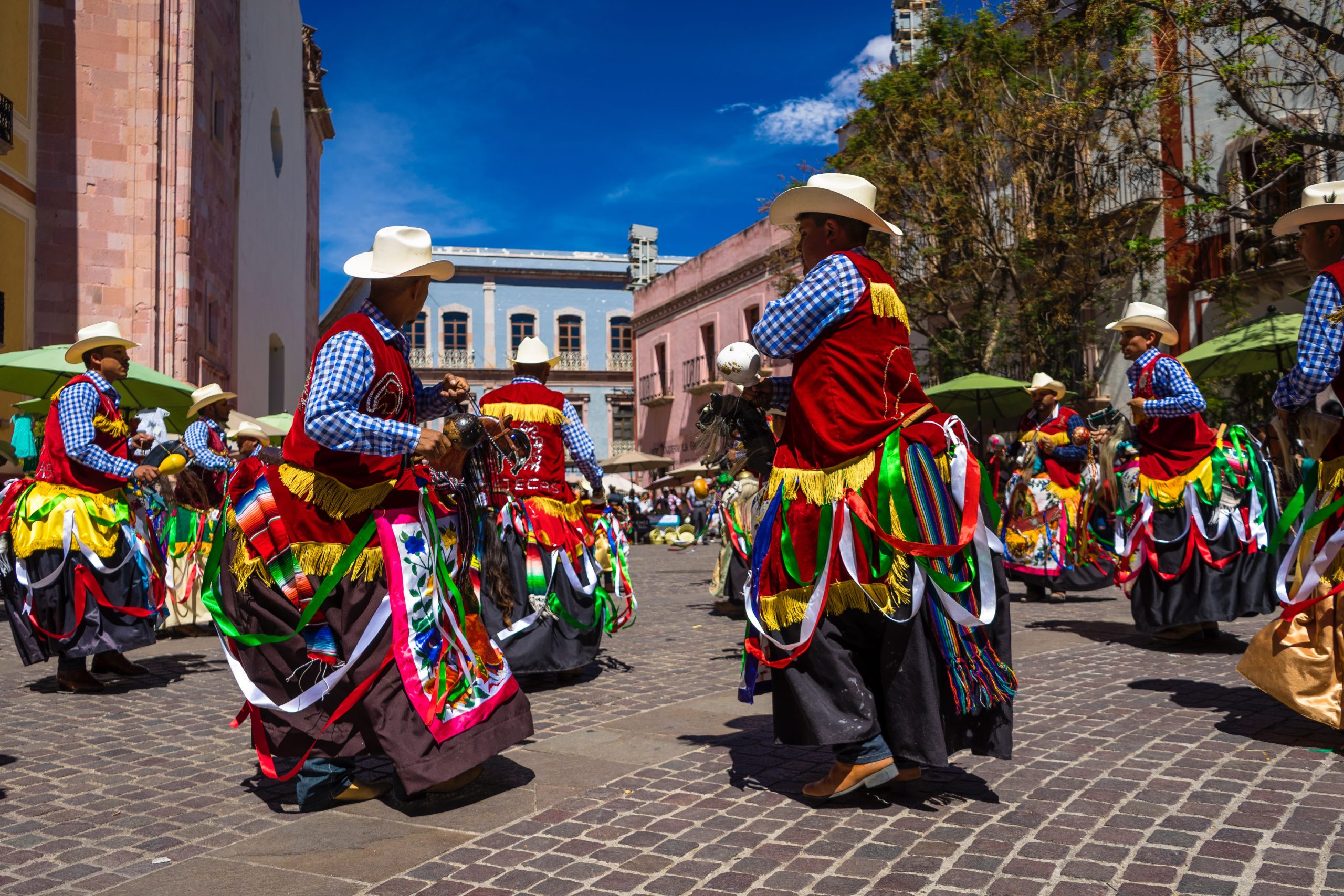 In an article about Fiestas Patronales, dancers perform a traditional Puerto Rican. dance on the street.