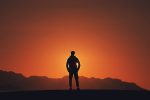 An article on 'the alchemist' has a picture of a man staring into the sunset