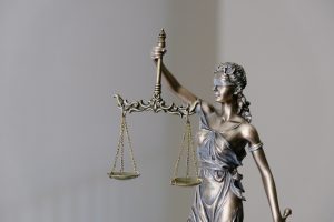 In an article about the just world hypothesis,bronze statue of blindfolded justice holding up balanced scales.