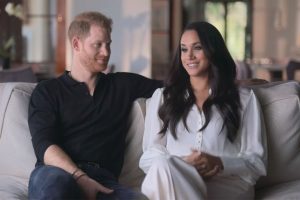 An image from Harry & Meghan showing Prince Harry and Meghan Markle seated on a couch