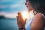 In an article about mindfulness, a woman meditates at sunrise.