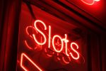 A red neon sign that reads "slots."