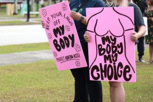 In an article about women's health, two protestors hold pink signs that read 'my body, my choice.'