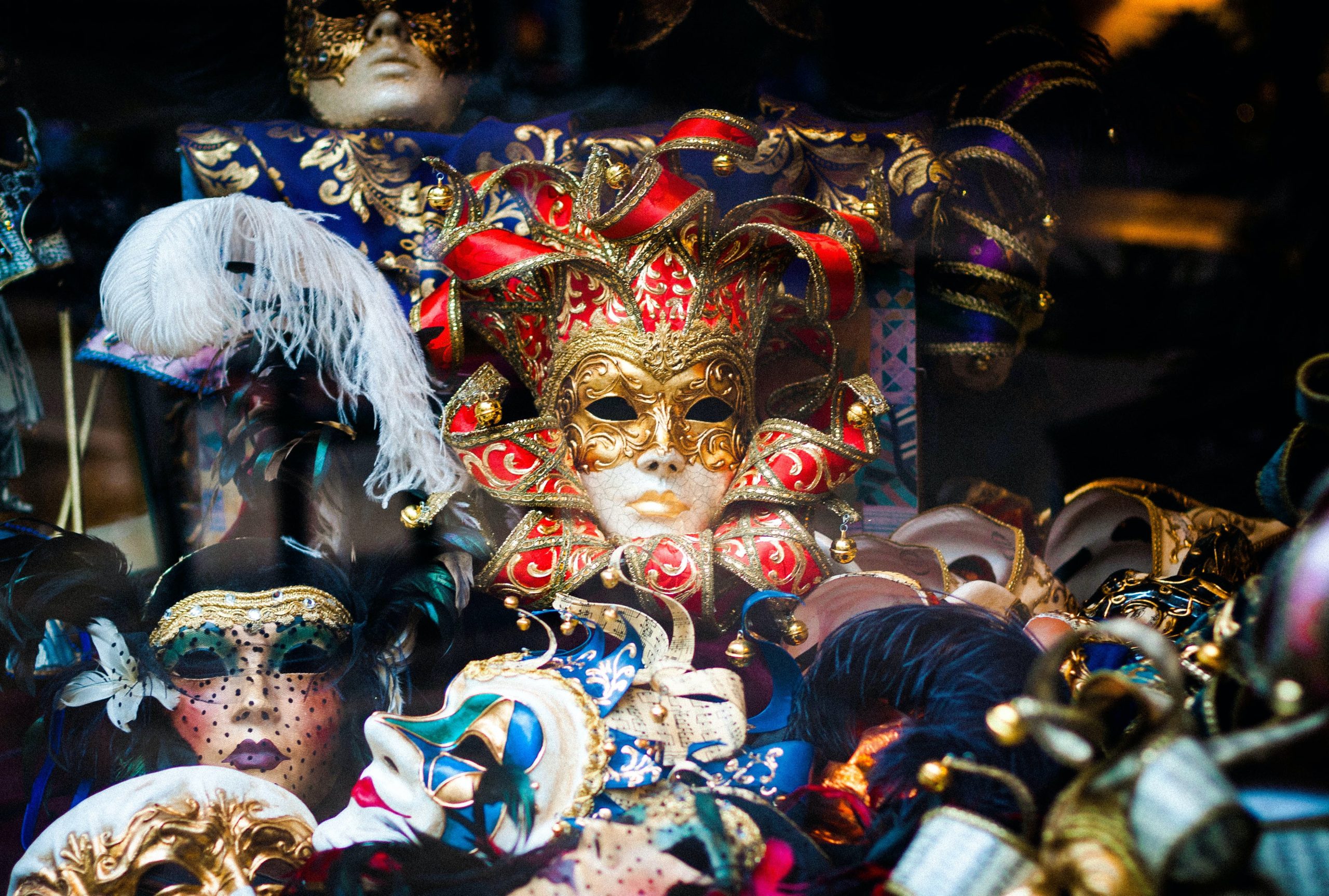 In an article about mardi gras, a pile of multi-colored Venetian masks.