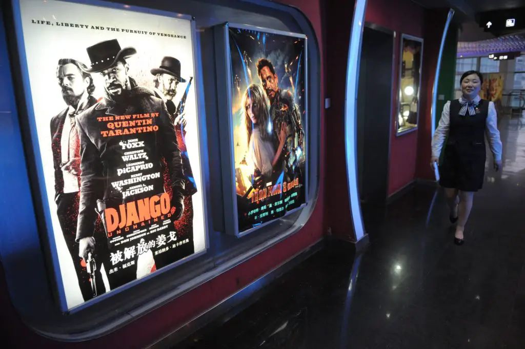 A picture of movie posters on the wall of a theater.