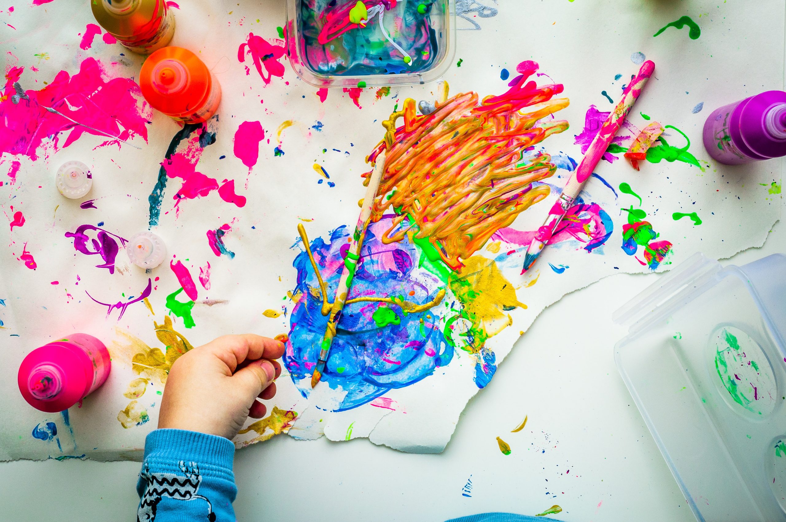In an article about creativity, a photo of a child finger painting.