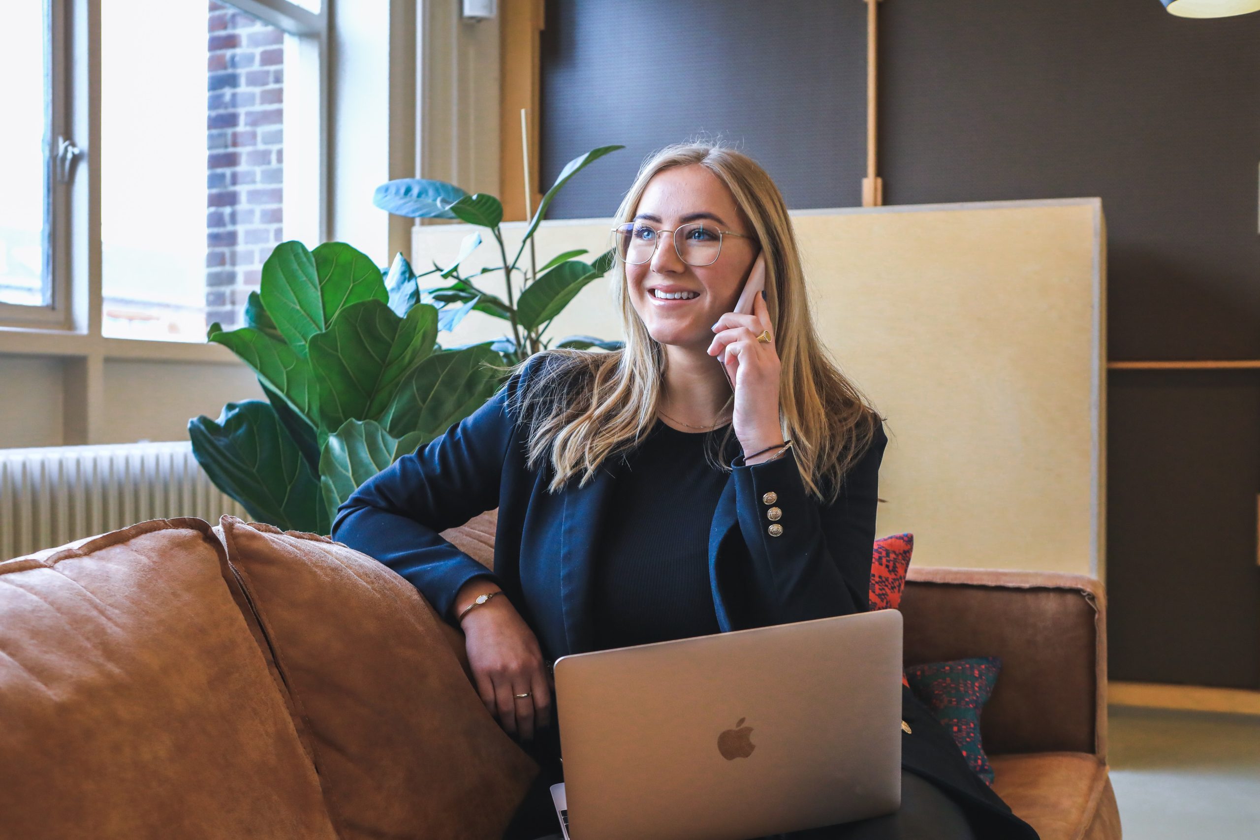 In an article about becoming a recruiter, a woman talks on the phone with a laptop in her lap.