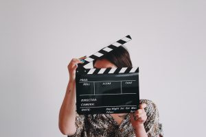 In an article about female film directors, a woman poses behind a film clap board.