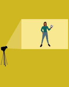 In an article about female-led comedies, a projector shines an image of an actress holding a comedic mask onto a yellow screen.