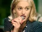 In an article about the band No Doubt, singer Gwen Stefani sings into a microphone.