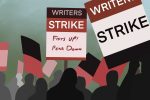 In an article about the WGA strike, silhouettes of writers picket with signs that read 'writer's strike' and 'Fists up! Pens Down.'