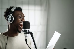 In an article about becoming a voice-over artist, a person holds a script and speaks into a microphone.