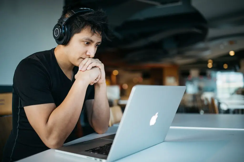 In an article about being a transfer student, a young person looks thoughtfully at their computer screen.