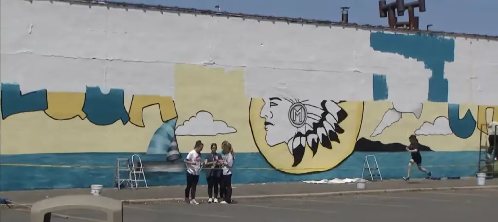 In this article about Massapequa, a mural of the town's mascot, a Native American chief is reaching completion.