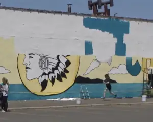 In this article about Massapequa, a mural of the town's mascot, a Native American chief is reaching completion.