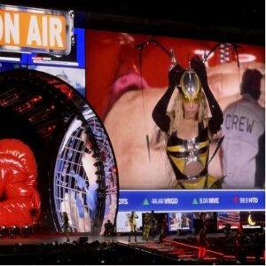 Beyonce dancing in a plastic bee outfit, next to a big "On Air" sign and a giant disco ball.