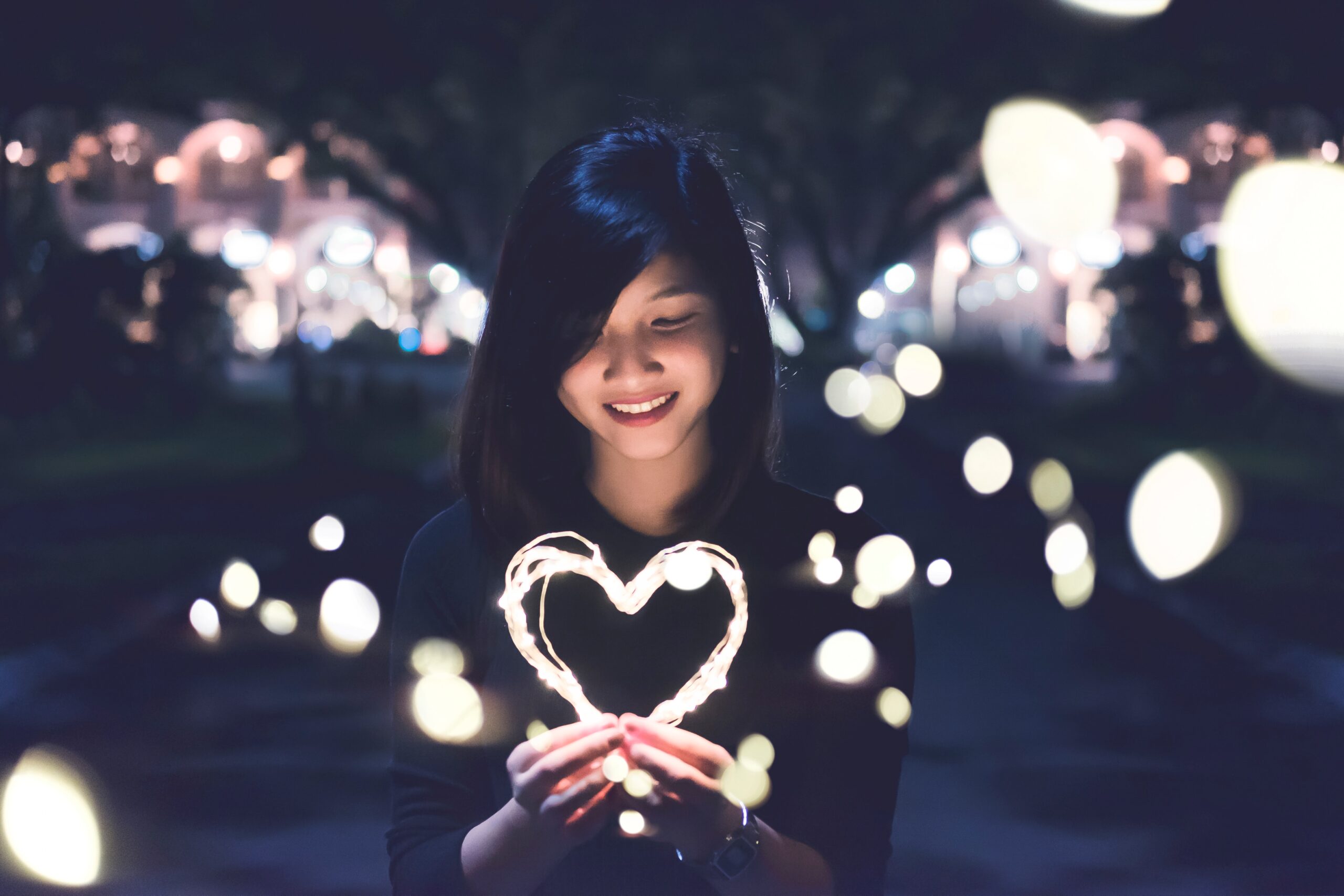 In an article about asian brides a woman holding a heart shaped light.