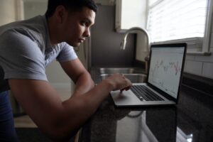 In an article about investing Man sitting next to computer