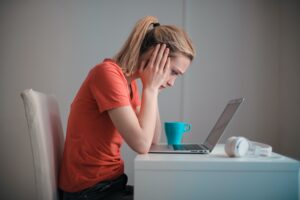 In a story about student challenges a female student at her desk in front of a computer