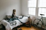 In an article about VPN a woman sitting on a bed in her dorm room in front of a computer