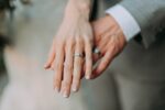 In an article about wedding band trends couples hands with wedding bands.