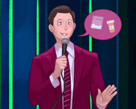 In an article about John Mulaney's controversies and comedy career, a man stands with a red suit on and red tie. He holds a microphone as a word bubble is beside his face with a bag of white powder and pill bottle.