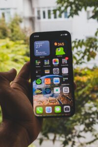 In a story about mobile app a man holding a cell phone with apps on the screen