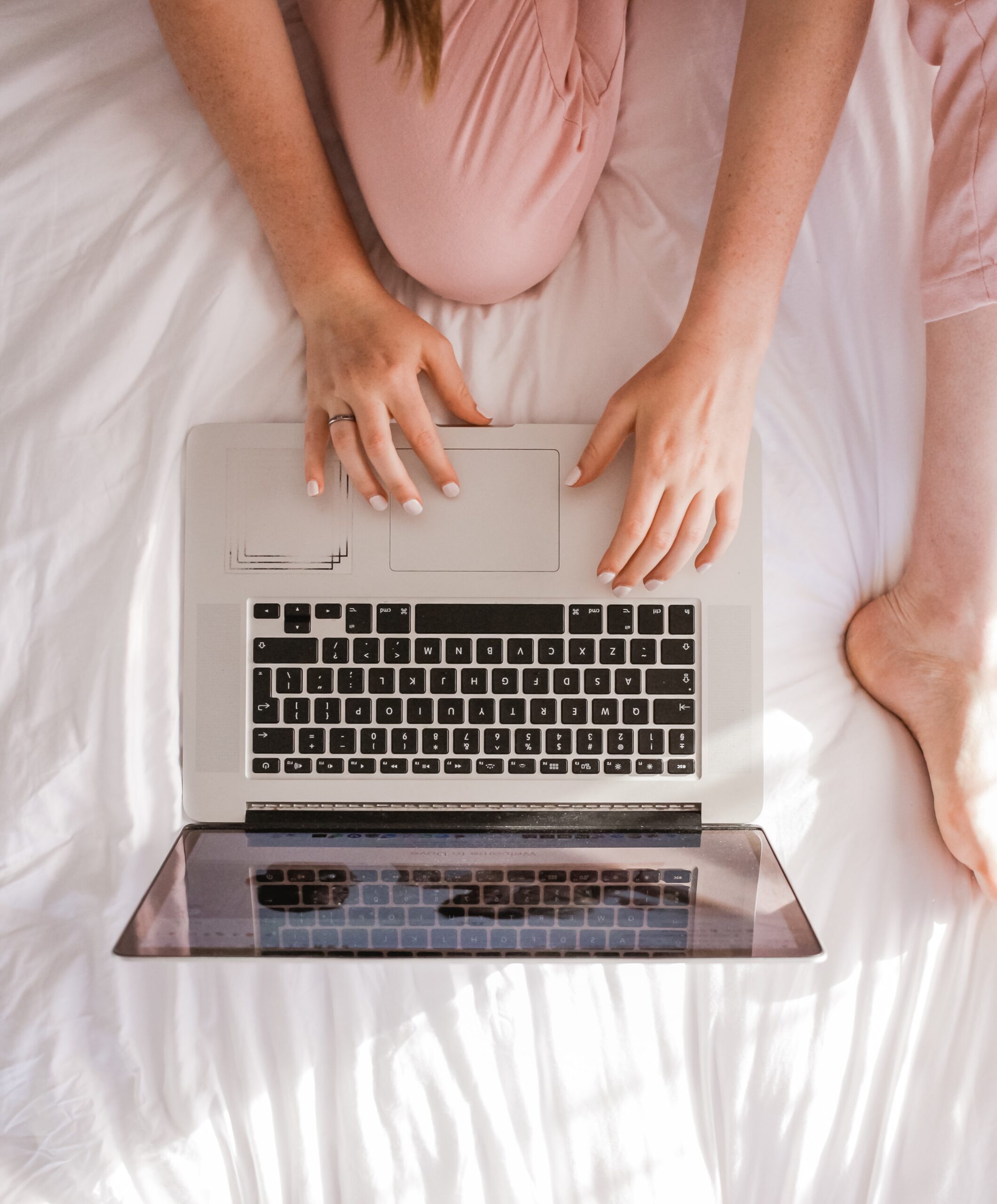 In an article about student essays woman on bed with a laptop