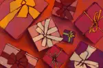 Against a rich red background, scattered Christmas gifts lay in bowed boxes of pink, purple, and maroon.