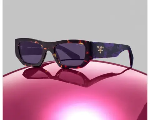 Prada sun glasses on the hood of a car