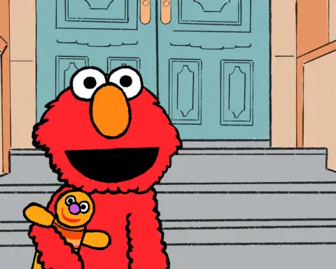 Elmo stands in front of a grey staircase, flanked by brown walls, leading up to a set of blue doors. He is hugging an orange dolls close to his chest as he gives the audience a smile; the special kind, which is warm, and reassuring and promises you that everything will turn out all right in the end.