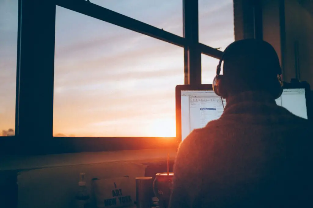 Man working remotely at home looking at sunrise